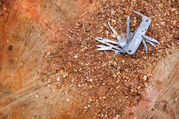 Cuchillo multifunción pegado en el tocón del árbol . — Foto de Stock