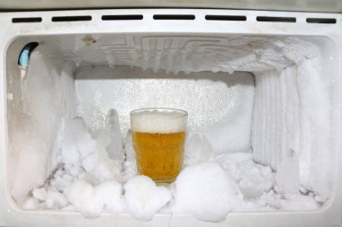 A glass of beer in the refrigerator. clipart