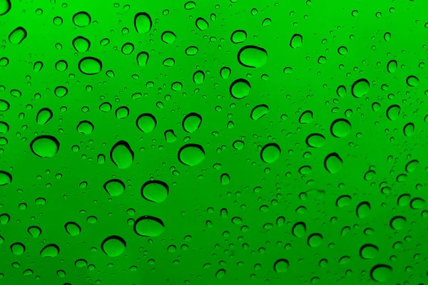 Schöne Regentropfen auf dem grünen Glas. — Stockfoto