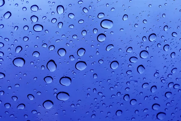 Schöne Regentropfen auf dem blauen Glas. — Stockfoto