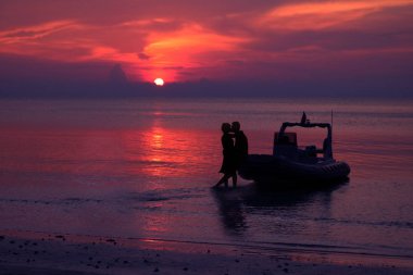 Sandallar özel tekne ile sahilde öpüşme siluet Çift.