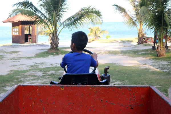 Asian boy drive a truck on the beach