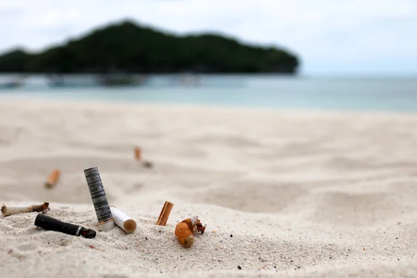 Sigarettenpeuken en de asbak op het strand. — Stockfoto