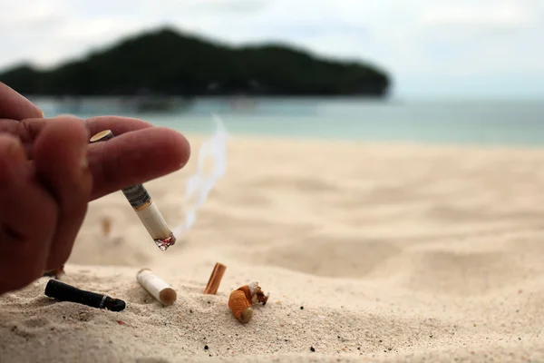 在沙滩上手烟和烟灰缸 — 图库照片