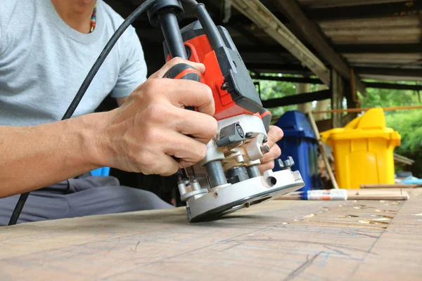 Trabajadores que utilizan enrutamiento eléctrico para cortar rayas en la madera . — Foto de Stock