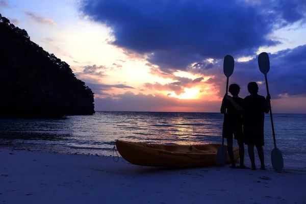 Silhouette kayaking on the beach with tourist girl looking blue sky sunset. — Stock Photo, Image