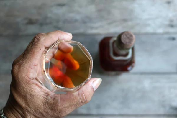 Bitkisel Likör şişesi ile bir bardak içinde yerel viski.