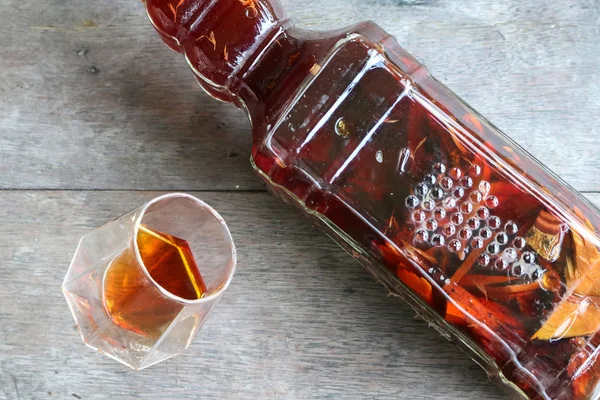 Whisky local dans un verre avec bouteille de liqueur aux herbes . — Photo
