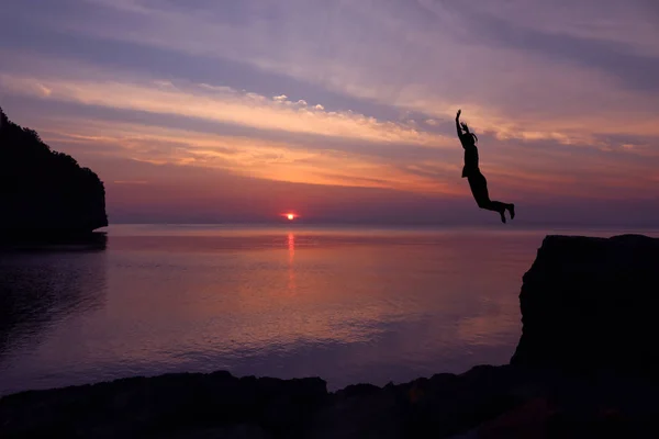 Asiático niñas saltar desde un acantilado en el mar episodio puesta de sol, Salto al mar —  Fotos de Stock