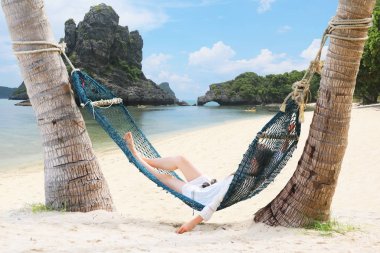 Rahatlatıcı ve bir hamak sahilde yatan turist kız
