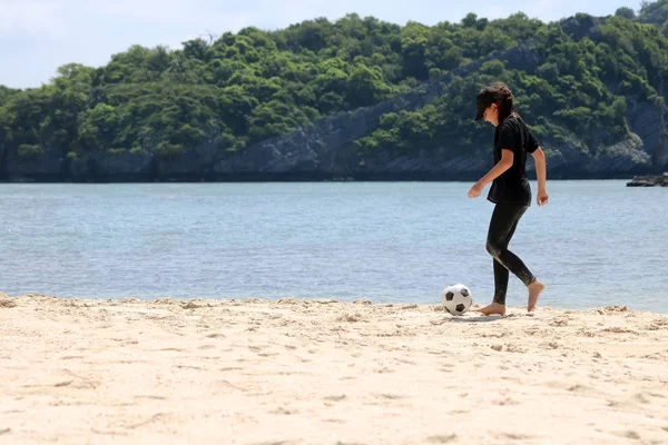 Menina adolescente jogando futebol na praia de areia branca — Fotografia de Stock