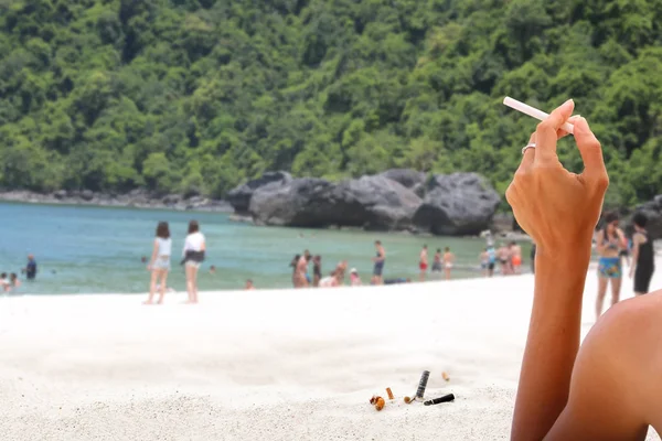 Dohányzás cigaretta csikk, a homokos strand — Stock Fotó