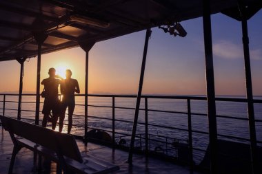 Güneş ışığı arayan çift turist denize feribotla yansıtır.