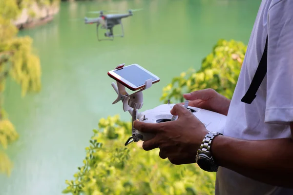 Ręka kontrolowanie kamery drona latające w zielonej laguny — Zdjęcie stockowe