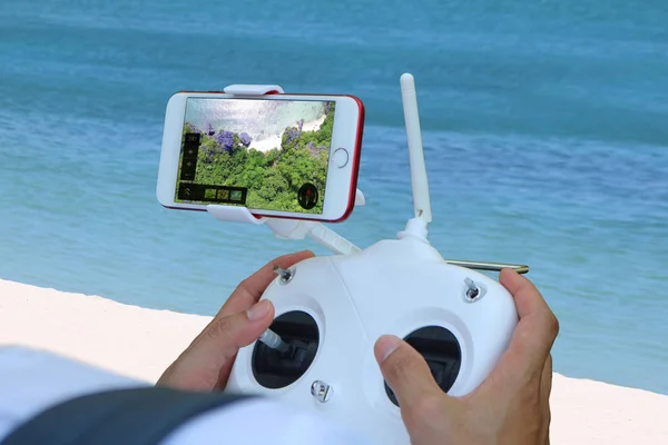 Kézi ellenőrző drone fényképezőgép-val a telefon kavics kilátással az óceánra — Stock Fotó