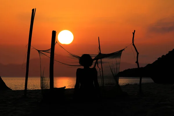 Silueta de una mujer acampando sola en la playa con mosquito n — Foto de Stock