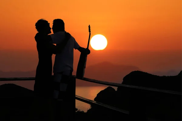 Silhouette romantic couple kissing on the top of the mountain — Stock Photo, Image