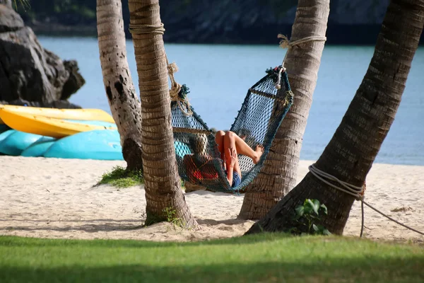 Ragazze turistiche rilassanti e sdraiate su un'amaca sulla spiaggia — Foto Stock