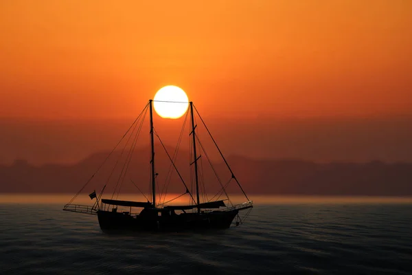 Voilier dans la mer avec coucher de soleil ciel rouge — Photo