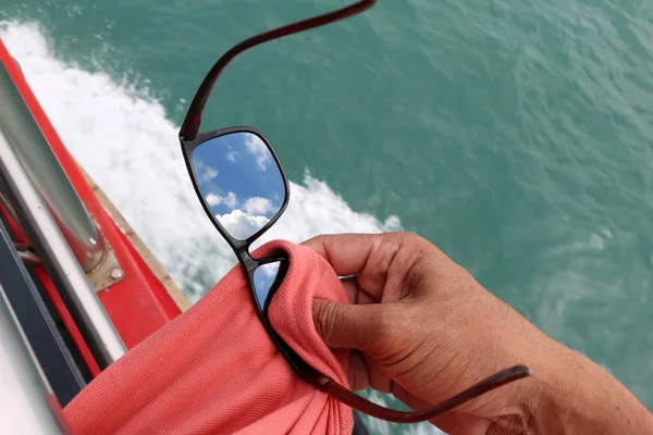 Os homens usaram um shirttail limpando os óculos de sol no barco de turismo — Fotografia de Stock