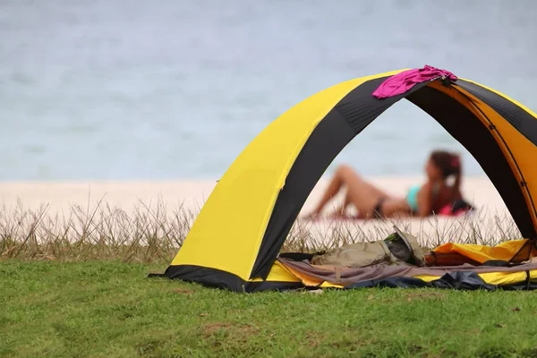 Acampar na praia, Mulheres de biquíni relaxando perto da tenda — Fotografia de Stock