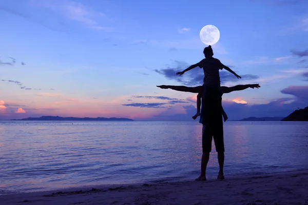 Silhouet vader en dochter op het strand met de lucht van de maan — Stockfoto