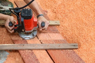 Ahşap fabrikasında elektrik routering kullanarak ele