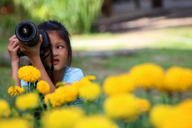 Asyalı kız bahçede DSLR fotoğraf makinesi kullanmayı öğrenme