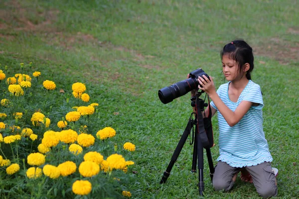 Asiatisk flicka lära sig att använda dslr kameran i trädgården — Stockfoto