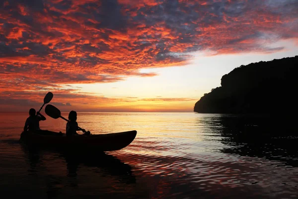 Silhouette mother and daughter kayaking in the ocean around the — Stock Photo, Image