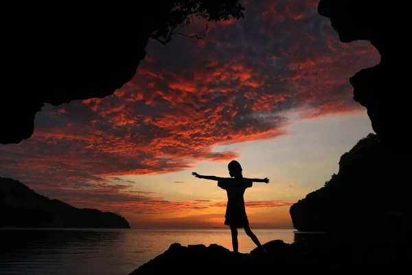 Silhouette fille debout et étirer les bras sur les rochers rouge s — Photo