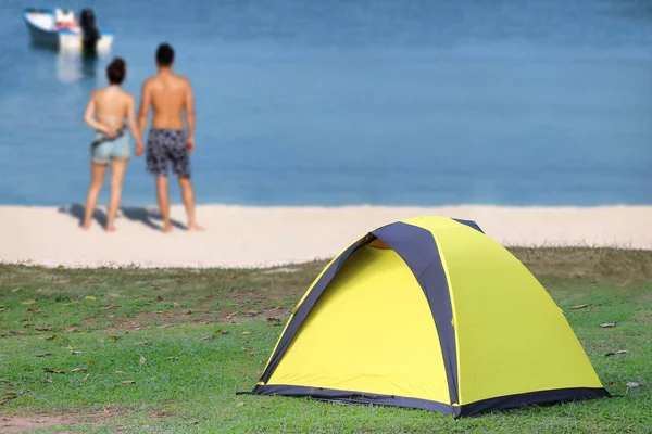 Paar zeltet am weißen Strand mit gelben Zelten — Stockfoto