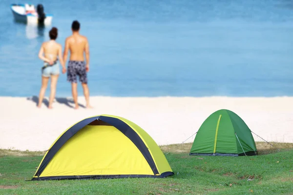 Campeggio sulla spiaggia con coppia sfocata sfondo rilassante — Foto Stock