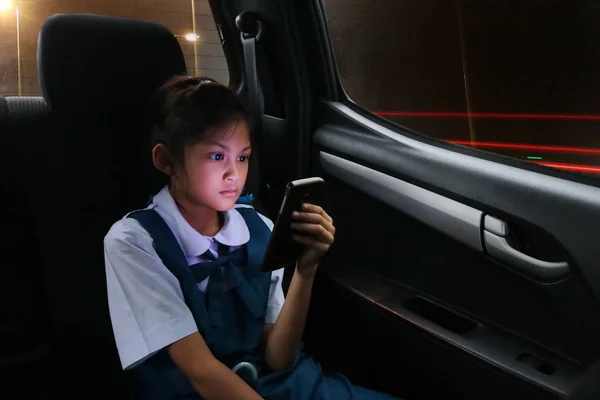 Asiático estudiantes chica disfrutar de un teléfono en el personal coches mientras bac —  Fotos de Stock