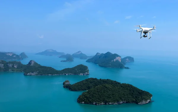 Cámara Flying Drone o UAV en el cielo azul con océano e isla —  Fotos de Stock