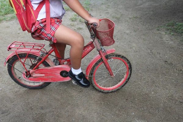Хлопчик у шкільній формі зі старим велосипедом — стокове фото