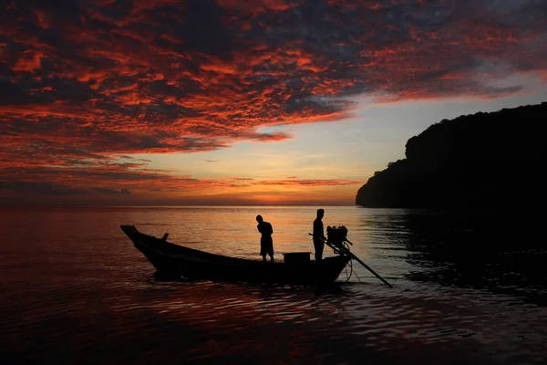 Silueta del bote de cola larga con puesta de sol de cielo rojo — Foto de Stock