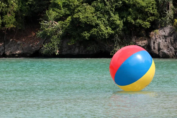 Grote kleurrijke beach ballen op het water in de zee aan het strand. — Stockfoto