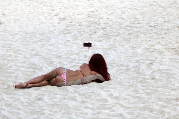 Asian tourists girls wearing bikini enjoy selfies by the smartph