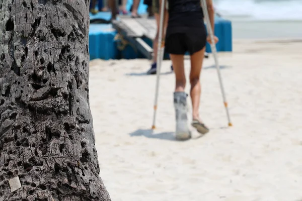 Ongeval toeristische meisje door de krukken zijn oplopend naar de drijvende — Stockfoto