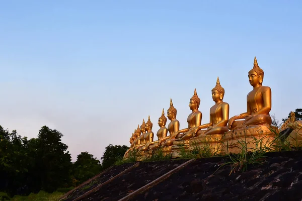Золота статуя Будди храму Пху Салао в прекрасному заході сонця. — стокове фото