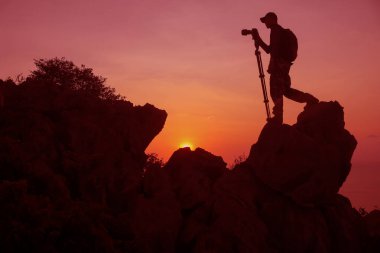 Fotoğrafçı Tayland 'da gün batımında fotoğraf çekmek için dağın tepesine tırmanıyor..