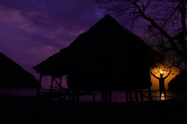 The fishermen live in a bamboo hut by the sea in the morning dark sky sunrise background.