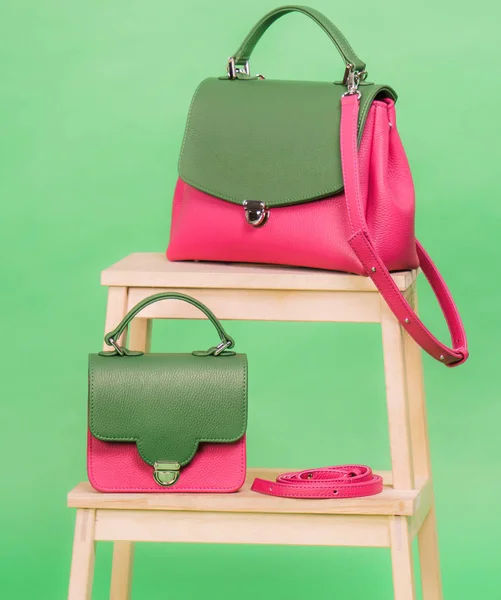 Rosa e verde um estilo mulheres bolsas de pé em uma cadeira — Fotografia de Stock