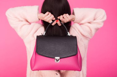 Kadın çanta arkasından iki eliyle tutarak pastel pembe ceket