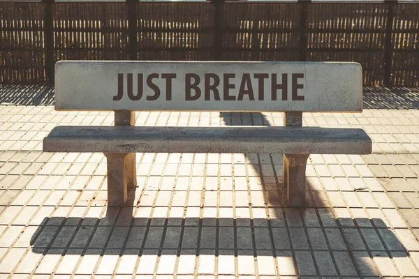 Just breathe text on a concrete bench — Stock Photo, Image