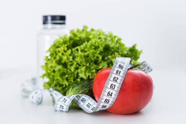 Dieting, tape measure with vegetables and water