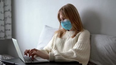 Coronavirus. Koruyucu tıbbi maske takarak evden çalışan genç bir iş kadını. Koronavirüs için karantinada olan iş kadını koruyucu maske takıyor.