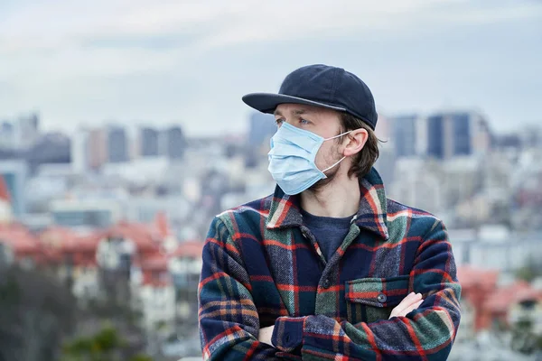 Smoke danger or a virus in the city. Man in medical mask with big city view. Pandemic and epidemic protection and country on a quarantine