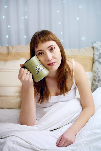 Young woman hold mug with print "I hate morning"